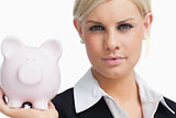 Beautiful businesswoman holding a piggy-bank