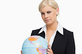 Serious blonde in suit holding a globe