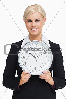 Serious blonde in suit holding a clock