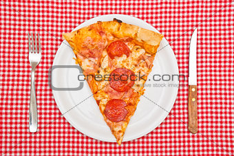 Pepperoni pizza slice on white plate