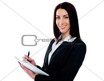 Young beautiful businesswoman writing on clipboard