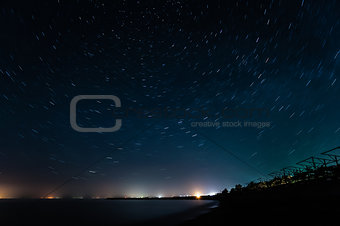 Night coast under star trails rounded