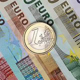 One Euro coin on banknotes