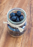 Blueberries in a glass jar on a wooden board