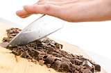Female hand chopping dark chocolate