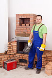 Worker mounting the door of a brick masonry heater