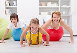 Healthy family exercising with push up on large balls