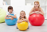 Happy healthy family relaxing in the middle of gymnastic exercis