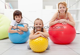 Happy healthy family relaxing in the middle of gymnastic exercis