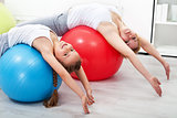 Woman and little girl doing stretching exercises