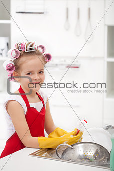 Little girl with big curls doing the dishes