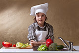 Little boy with chef hat washing vegetables