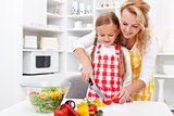 Woman and little girl preparing a vegetables salad