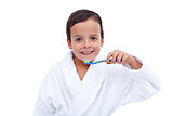 Little boy in bathrobe washing teeth