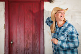 Beautiful Cowgirl Against Old Wall and Red Door