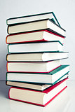 Stack of books on white reflective surface