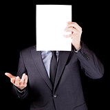 Businessman holding  an empty sheet of paper in front of his fac