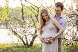 Young pregnant couple outdoors in spring