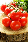 branch of ripe red tomato on a wooden stump