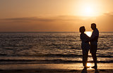 Happy Senior Couple Embracing on Sunset Beach