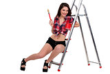 Sexy woman sat on ladder holding paint pot