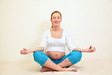 pregnant woman sitting in a lotus position