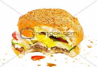 Bitten burger with vegetables and crumbs isolated on white