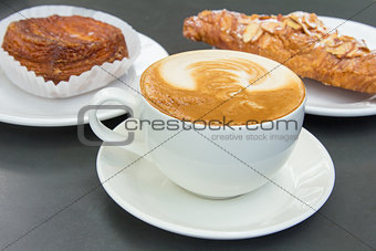 Cup of Caffe Latte with Pastry Background