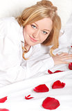 Happy Woman In Bed With Rose Petals
