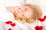 Happy Woman In Bed With Rose Petals