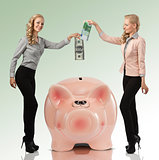 two smiling girl saving their money euro dollar