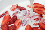 flowing milk splashes on sliced strawberry