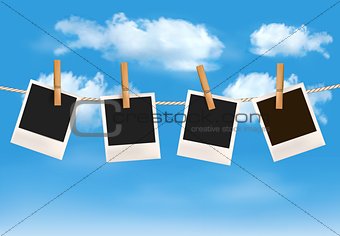 Background with photos hanging on a rope in front of a blue sky 