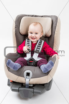 happy child in booster seat for a car in light background