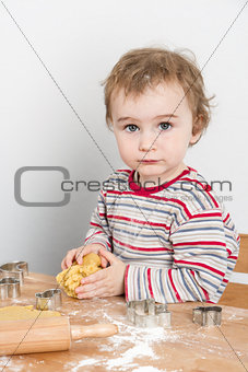 young child making cookies