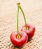 Two Red Ripe Sweet Cherries on a Wooden Table