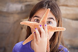 Young Girl Playing with Starfish