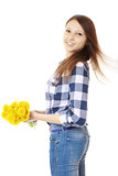 Girl with bouquet yellow wildflowers. Teenage Girl in jeans and a plaid shirt, holding a bouquet of dandelions.