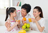 Asian family drinking orange juice. 