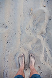 Men's barefoot feet in the sand