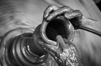 Man's hands creating pottery on wheel