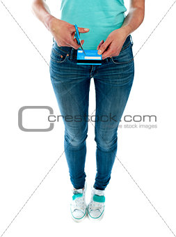 Woman cutting credit card with scissors