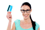 Portrait of young smiling woman holding credit card