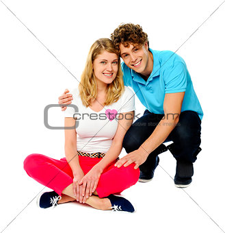 Teenage couple sitting on floor, studio shot
