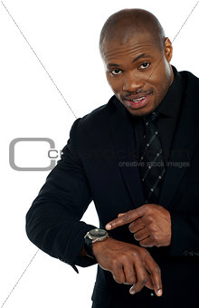 African male indicating towards wrist watch