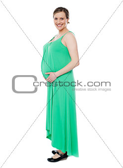 Pregnant woman posing in trendy fashion wear