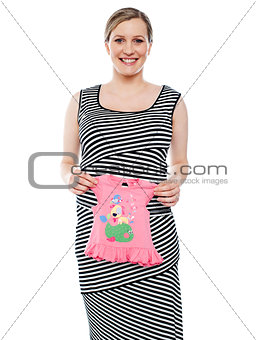 Young mum showing pink baby cloth to camera