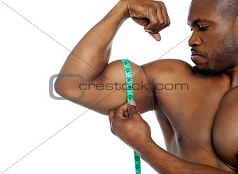 Handsome guy measuring his biceps