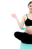 Cropped image of a pregnant lady doing yoga
