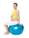 Relaxed pregnant woman sitting on pilate ball